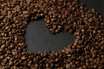 Coffee grains on a dark background. A delicious fragrant coffee of the best varieties. Coffee texture. Coffee beans background.Heart of coffee