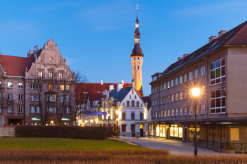 Fototapeta premium Beautiful illuminated street with Town Hall in Medieval Old Town on the morning blue hour, Tallinn, Estonia