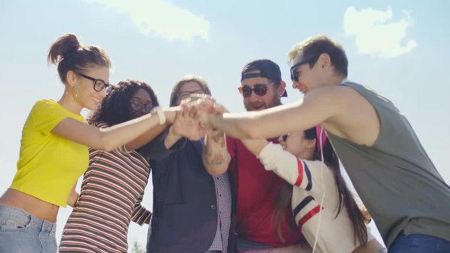 Multicultural group of friends stack their hands
