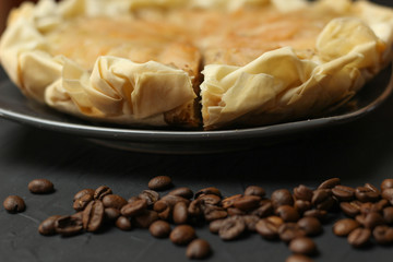 Apple cake with almond cream on a dark background. Baked cake with coffee nd coffee beans. Pie for the whole family on a sunny day