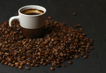 A cup of coffee with coffee beans on a dark background. A delicious fragrant coffee of the best...