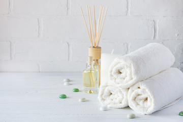 SPA aromatherapy background.  Still life with white towel, bath oil, massage brush and candle.