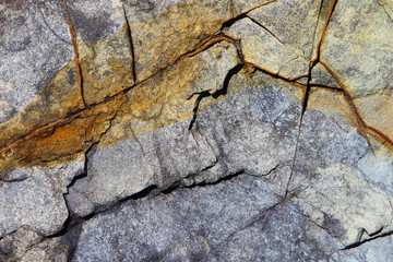 Grey and brown stone surface texture with cracks. Old castle walls.