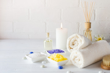 Fototapeta na wymiar Body care set for peeling. With towel,white lily, sea salt, bath oil, sugar body scrub, massage brush and candle
