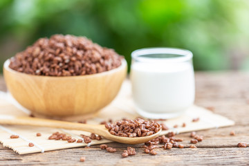 Breakfast cereal, Puffed rice with cocoa in bowl and glass of milk on wooden table