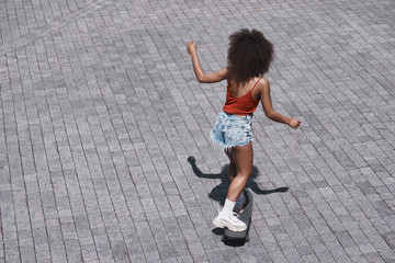 Young woman free style on the street riding skateboard on the ro © Friends Stock