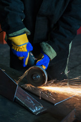 Industry, job concept - worker cutting metal with grinder