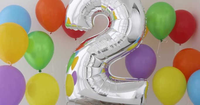 Number 2 (two) of color balloon on a light background. Birthday balloon for baby with , rainbow color- red, orange, yellow, green, sky blue and fiolet balloons