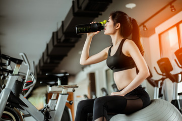 Fototapeta na wymiar young fitness woman tired in gym drink protein shake.exercising concept.fitness and healthy lifestyle