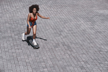 Young woman free style on the street riding skateboard on the ro