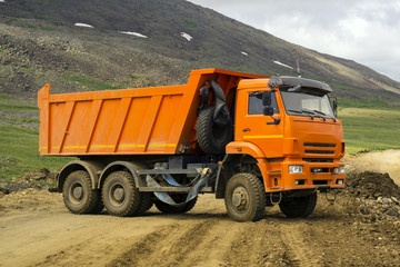 dump truck turns on the mountain road under construction