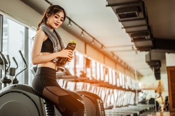young fitness woman tired in gym drink   protein shake.exercising concept.fitness and healthy lifestyle .