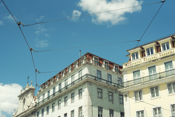 Detalle minimalista de catenarias de tranvía junto a edificios