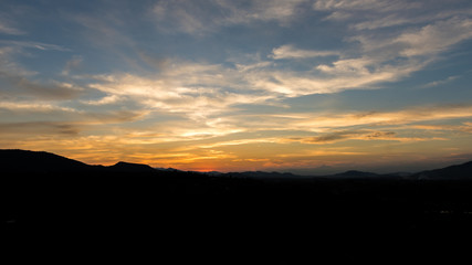 Cloudscape after sunset above the silhouette hills