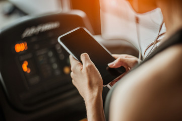 Fitness woman is choosing music to run on a treadmill.exercising concept.fitness and healthy lifestyle.