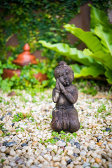 Wooden doll in the small garden