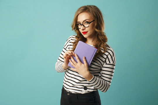 Pretty smiley blonde girl student with book wearing glasses