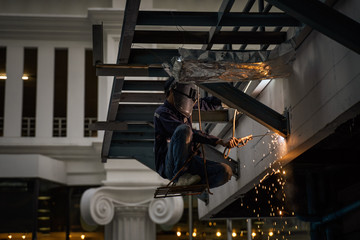 Engineer steel welding and sit on chair hang on building roof