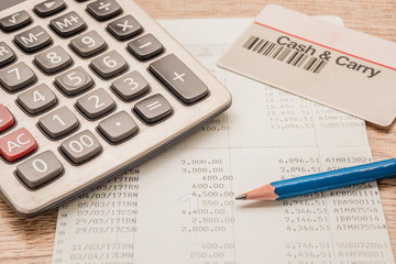 Calculator, cash card, pencil, bankbook Put on a wooden table.