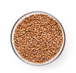 Dry buckwheat in ceramic bowl isolated on white.