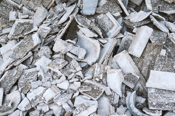 Texture of a bat of old tiles from the roof of an old house for demolition. Gray broken shingles pattern