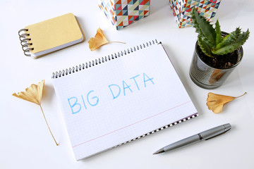 big data written in a notebook on white table