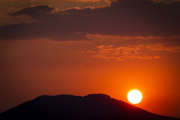 The sun going down the mountain with orange colors