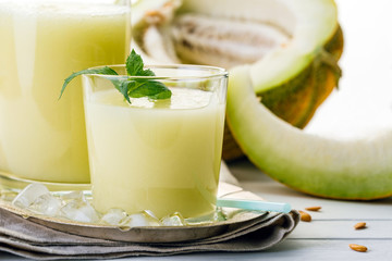 melon smoothie in glass and bottle on white background, summer drink, cocktail
