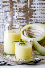 smoothies melon in a glass and a bottle on a wooden background, summer drink, cocktail