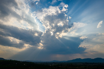 Rays of light shining through the clouds over mountains