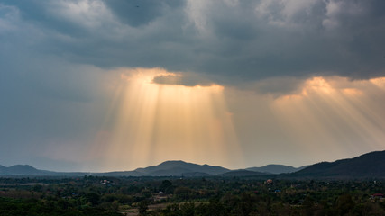 Rays of light shining through the clouds over mountains