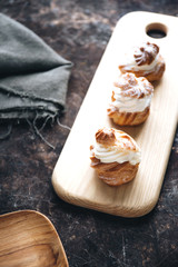 Choux pastry or choux cream or eclair dish on rustic background