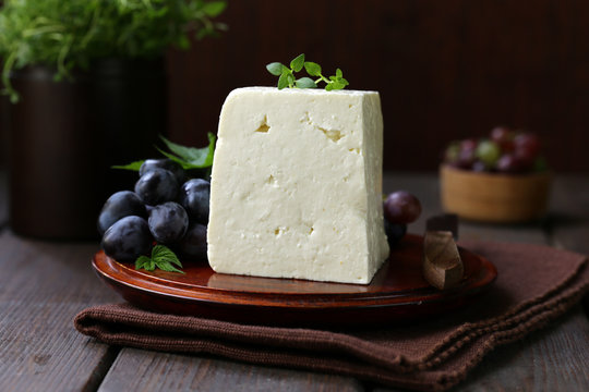 homemade cheese with grapes on a wooden board