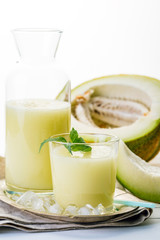 melon smoothie in glass and bottle on white background, summer drink, cocktail