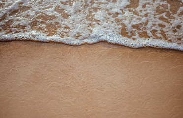 Soft wave on sandy beach. Background.