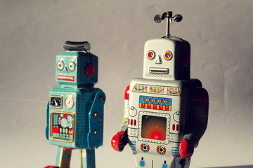 Two angry vintage tin toy robots, artificial intelligence, robotic drone delivery, deep machine learning concept