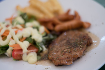 Soft focus of pork steak on dish.
