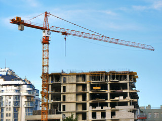 Construction site with crane and building. Crane and building under construction.
