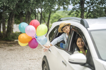 Happy family holding colorful balloons outdoor.