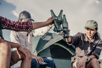  group of tourists clinking beer bottles in camping.adventure, travel, tourism, friendship and people concept.