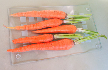 Young carrots on a glass surface. Candid.