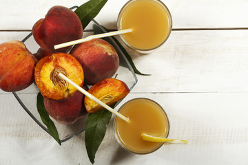 Peach fresh juice with fresh peaches on a white background. Top view, copy space. Fresh juice with peach. Healthy food fresh peaches.