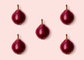 Pink purple pears on pink background. Minimalist style. Autumn harvest concept