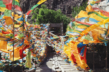 A Beautiful Old Wooden Bridge Decorated with Colorful Tibetan Mantra Flags on The Way Between Shangri-La, Yunnan and Yading, Daocheng, Sichuan, CHINA.