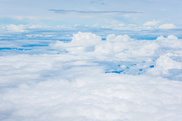 Fototapeta premium Aerial view of clouds and blue sky through airplane window