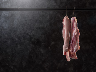 Pork hanging on hook against dark background,Pork  belly - Powered by Adobe