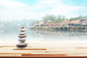 zen stones on wooden with village in Japan blurred background
