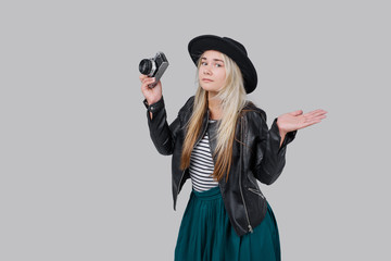 Fashion look, Surprised and disappointed young woman model with retro film camera. wearing an...