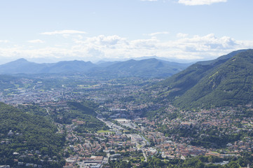 Fototapeta na wymiar View of small town surrounded by mountains on the shores of Lake Como in Italy