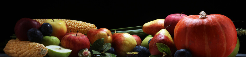 Various fresh fruits. Thanksgiving pumpkin, apples, and maize on rustic background.